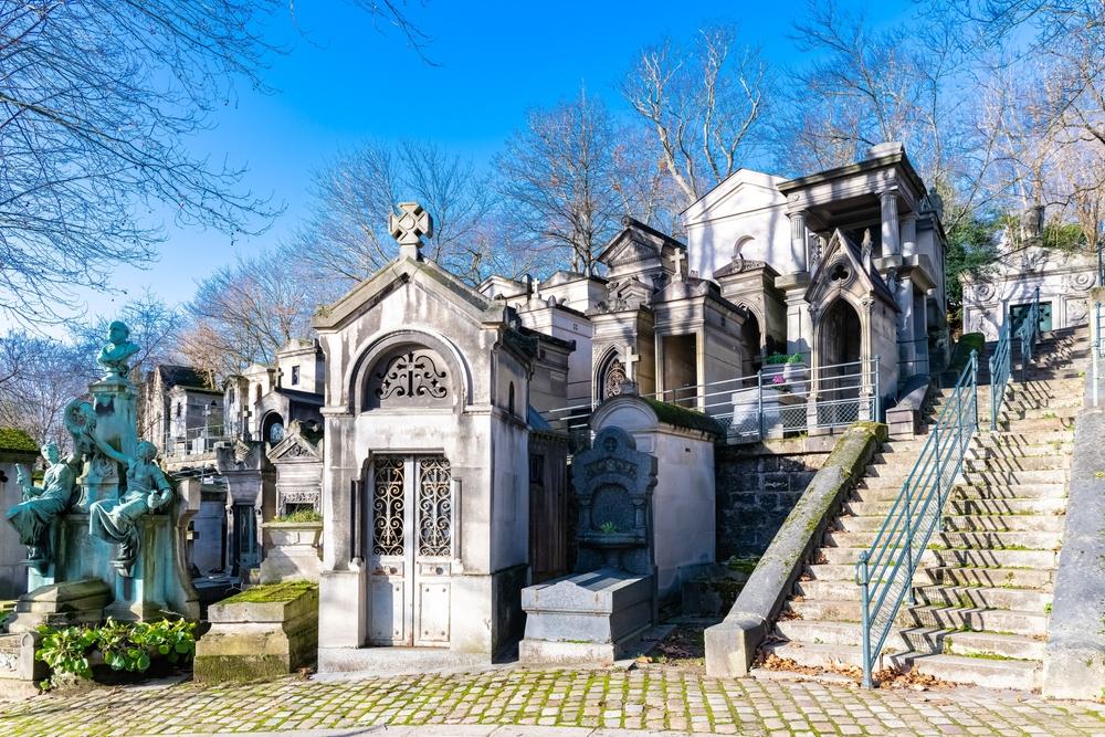 Der Père Lachaise Friedhof, gepflasterte Gasse mit Gräbern im Winter