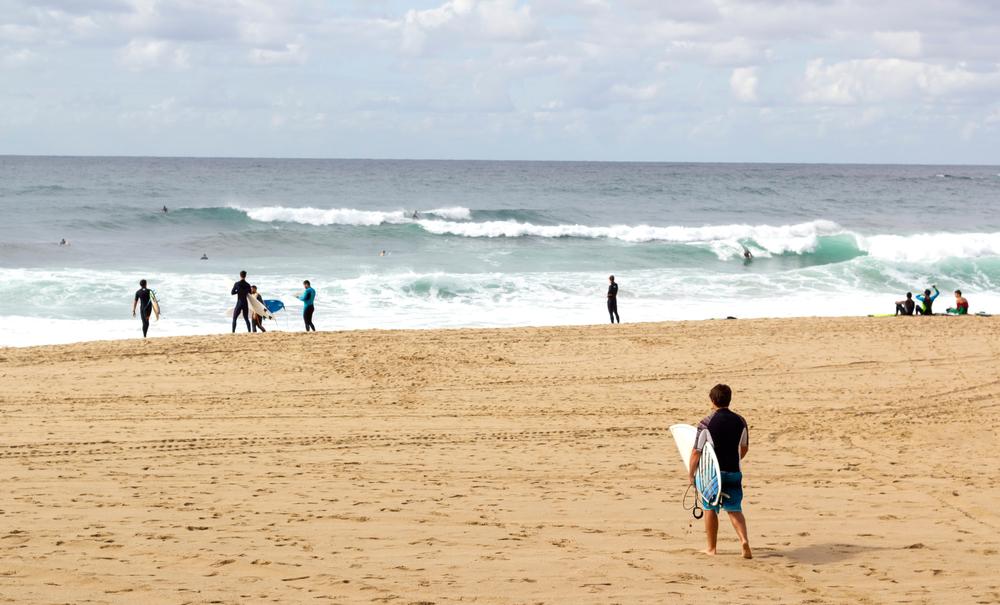 Unbekannter Surfer mit seinem Surfbrett, der zum Meer geht