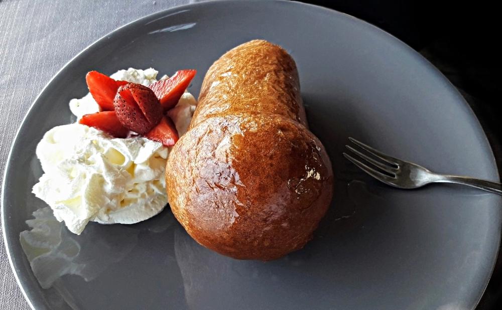 Babà; traditionelles neapolitanisches Dessert mit Sahne, Erdbeeren und Gabel darauf
